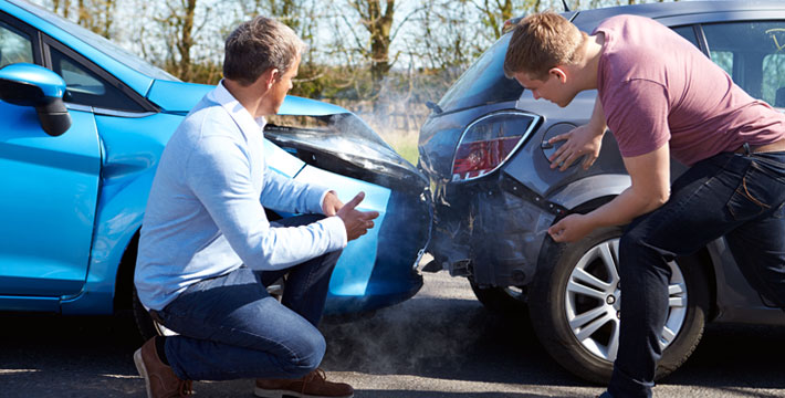 A photo of a car accident and drivers assessing the damage