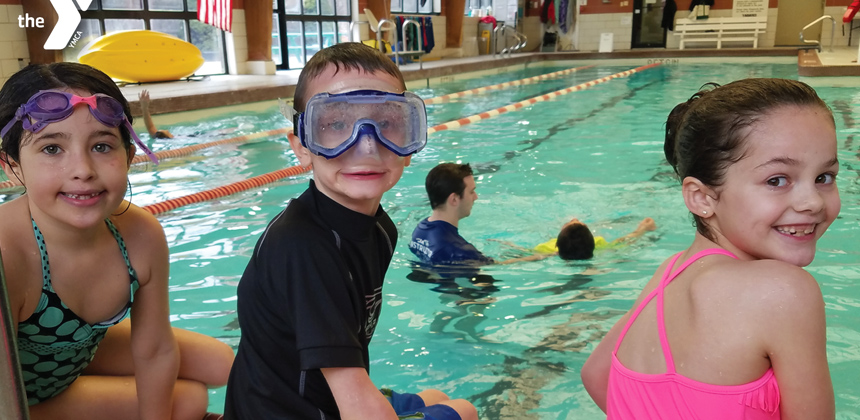 A photo of children at the local YMCA sitting by the pool