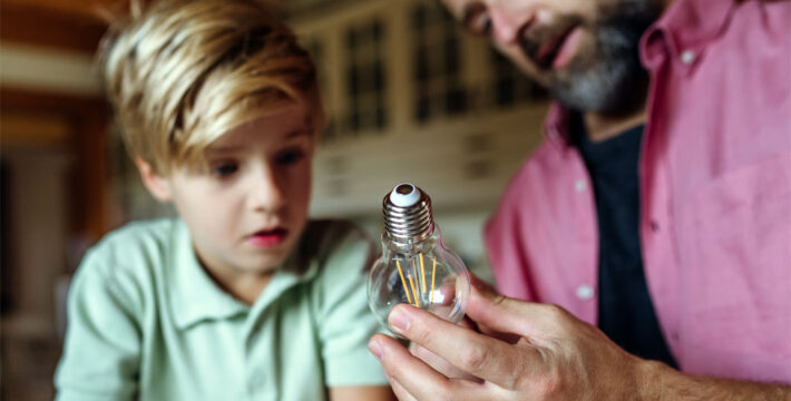 Image of a child and his father looking at an LED light bulb