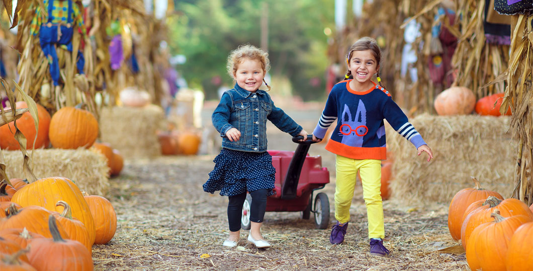 Image of two girls dressed for Halloween in a fall setting