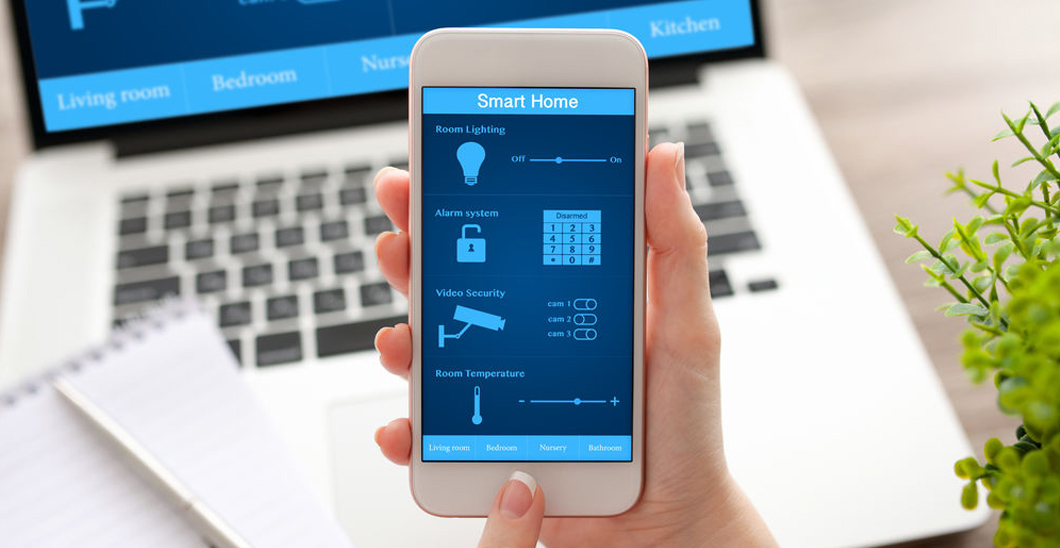 A photo of someone holding a mobile device with a smart home security system displayed