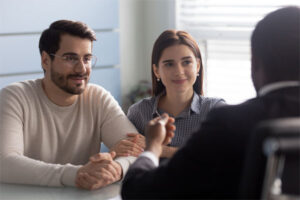 Image of a young couple talking with their insurance advisor